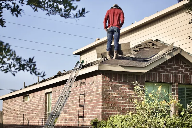 Professional roofer working on a residential roof in Landis